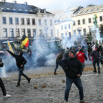Agricultores atiram batatas perto do Parlamento Europeu durante um protesto - AFP