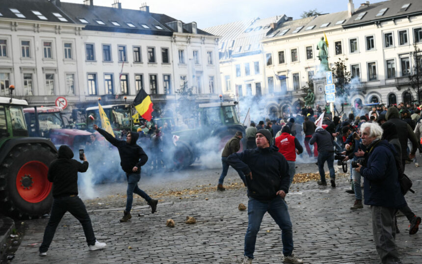 Agricultores atiram batatas perto do Parlamento Europeu durante um protesto - AFP