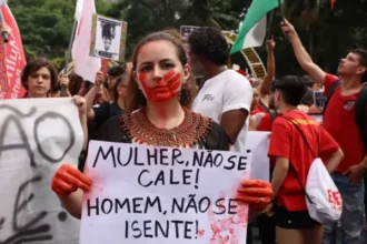 Manifestante participa de ato contra o feminicídio e cobra responsabilização dos agressores durante protesto no Rio.