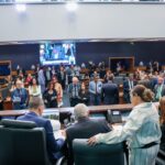 Vista da Mesa Diretora para o Plenário Deputado José Bonifácio, no Edifício Lúcio Costa, sede do Parlamento fluminense. Deputados, servidores e assessores acompanham a sessão enquanto parlamentares conversam no plenário da Alerj.