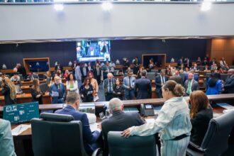 Vista da Mesa Diretora para o Plenário Deputado José Bonifácio, no Edifício Lúcio Costa, sede do Parlamento fluminense. Deputados, servidores e assessores acompanham a sessão enquanto parlamentares conversam no plenário da Alerj.