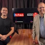 Empresário e pré-candidato a deputado federal Renato Araújo e o jornalista Eduardo Tchao posam no estúdio do Boletim Cast, em frente à mesa de gravação. Ao fundo, um monitor exibe as marcas do Canal do Tchao e do Boletim Cast.
