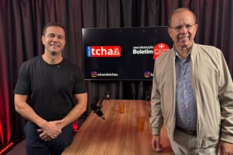 Empresário e pré-candidato a deputado federal Renato Araújo e o jornalista Eduardo Tchao posam no estúdio do Boletim Cast, em frente à mesa de gravação. Ao fundo, um monitor exibe as marcas do Canal do Tchao e do Boletim Cast.