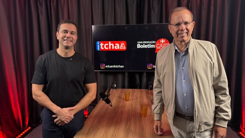Empresário e pré-candidato a deputado federal Renato Araújo e o jornalista Eduardo Tchao posam no estúdio do Boletim Cast, em frente à mesa de gravação. Ao fundo, um monitor exibe as marcas do Canal do Tchao e do Boletim Cast.