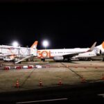 Aeronave da GOL estacionada no pátio do Aeroporto Internacional Tom Jobim (Galeão), à noite, conectada à ponte de embarque e iluminada pelos refletores do terminal, durante a inauguração da rota direta entre Rio de Janeiro e Nova York.