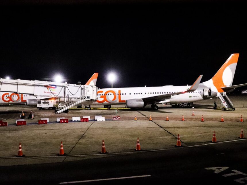 Aeronave da GOL estacionada no pátio do Aeroporto Internacional Tom Jobim (Galeão), à noite, conectada à ponte de embarque e iluminada pelos refletores do terminal, durante a inauguração da rota direta entre Rio de Janeiro e Nova York.