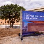 Canteiro de obras do Centro Cultural Rio-Áfricas, na Zona Portuária do Rio, com painel que apresenta o projeto arquitetônico.