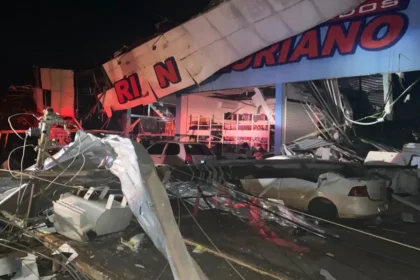 Estrutura de estabelecimento destruída e veículos atingidos após a passagem do ciclone bomba no Rio Grande do Sul.