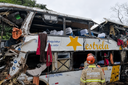 Bombeiro observa ônibus da Estrela Guia destruído após acidente na BR-040, em Petrópolis.