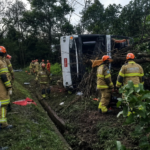 Bombeiros e socorristas trabalham ao redor de um ônibus tombado em uma área de mata às margens da BR-040, em Petrópolis.