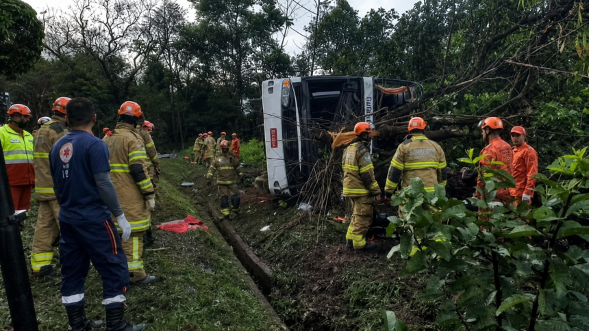 Bombeiros e socorristas trabalham ao redor de um ônibus tombado em uma área de mata às margens da BR-040, em Petrópolis.