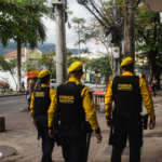 Três agentes da Força Municipal patrulham uma área comercial da Freguesia, em Jacarepaguá.