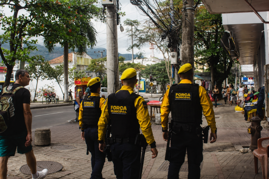 Três agentes da Força Municipal patrulham uma área comercial da Freguesia, em Jacarepaguá.
