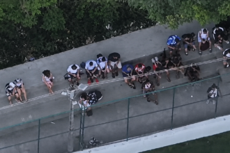 Imagem aérea mostra grupo de pessoas reunido ao lado de uma quadra no Complexo da Penha.