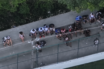 Imagem aérea mostra grupo de pessoas reunido ao lado de uma quadra no Complexo da Penha.