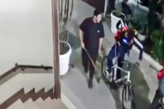 Câmera de segurança registra homem com um objeto comprido na mão próximo a entregadores e a uma bicicleta em Copacabana.