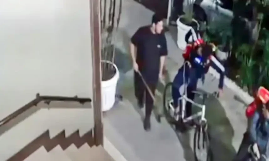 Câmera de segurança registra homem com um objeto comprido na mão próximo a entregadores e a uma bicicleta em Copacabana.