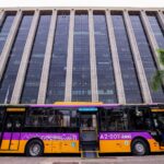 Novo ônibus do Sistema RIO, nas cores laranja e roxa, com piso baixo e rampa de acessibilidade aberta diante do Centro Administrativo São Sebastião.