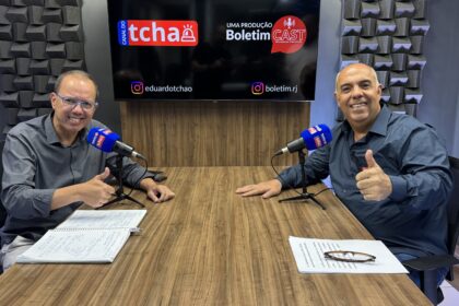 Eduardo Tchao e Marcos Braz sorriem e fazem sinal positivo durante a gravação do Boletim Cast.
