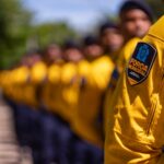 Agentes da Força Municipal do Rio em formação, com o emblema da corporação em destaque na manga do uniforme amarelo de um deles.