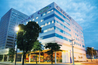 Fachada da sede da Cedae no Rio, com o nome e o logotipo da companhia no alto do prédio.