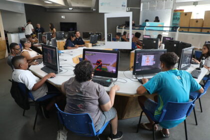 Pessoas de diferentes idades utilizam computadores em uma sala de uma Nave do Conhecimento no Rio.