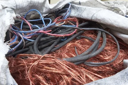 Cabos cortados e fios de cobre desencapados armazenados dentro de um saco branco.